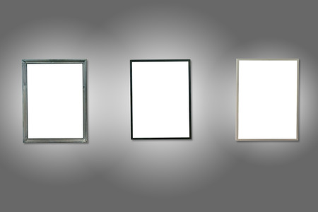 Three white isolated wooden frames on the gray wall