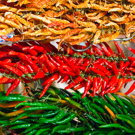 Bunches of red and green hot chilly peppers on the farmers market