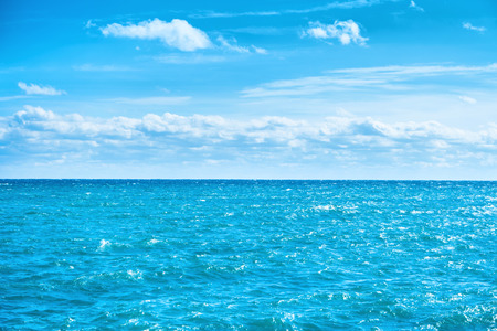Sea water and blue sky with white clouds. Ocean surface for natural backgroundの写真素材