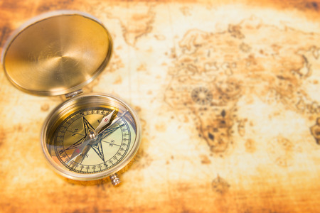 Old paper map with an ancient compass on it. Vintage travel background