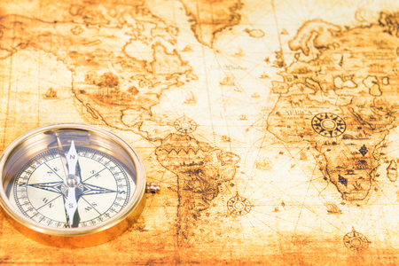 Old paper map with an ancient compass on it. Vintage travel background