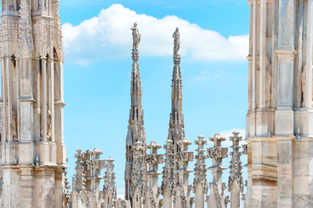 White marble statues on the roof of famous Cathedral Duomo di Milano on piazza in Milan, Italyの写真素材