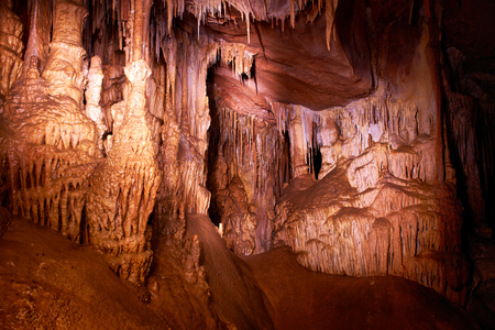 Cave dark interior with light, stalactites and stalagmitesの写真素材