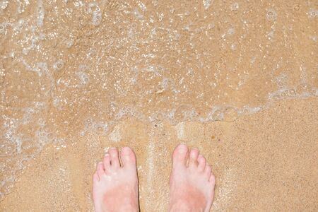 Closeup view of bare human feet on sand beach background. Summer vacation conceptの写真素材