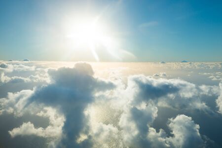 Airplane view of beautiful landscape with gold colored clouds, ocean and bright shining sunの写真素材