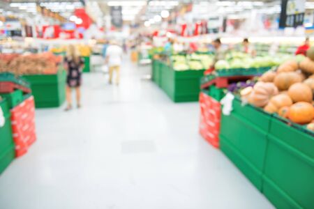 Market shop and supermarket interior in vegetable section with customers as blurred store backgroundの写真素材