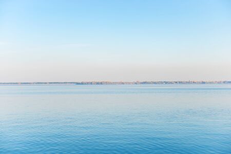 Calm landscape with sea water and a coast on horizon