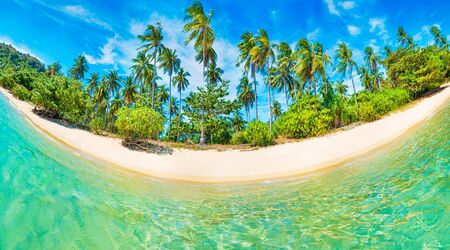 Panorama of beautiful beach on paradise round tropical island with coconut palm trees, white sand, blue water and no peopleの写真素材