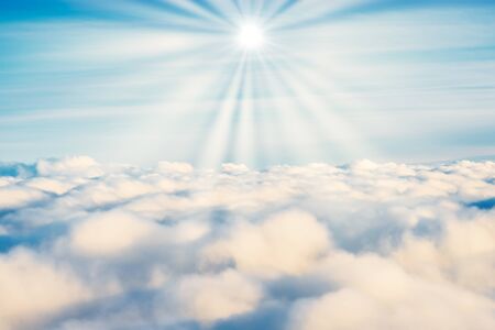 White clouds on blue sky with sun rays as cloudscape nature backgroundの写真素材