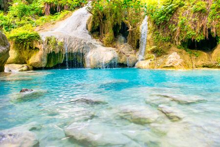 Tropical landscape of rock cascades of waterfall with stones in emerald blue lake in wild jungle forest. Erawan National park, Kanchanaburi, Thailandの写真素材