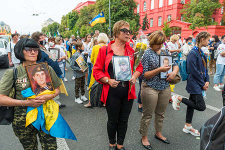 KIEV, UKRAINE - AUGUST 24, 2020: People with portraits of their killed in war relatives on March of defenders, parade in Kyiv, dedicated to the Independence Day of Ukraine, 29th anniversary.のeditorial素材