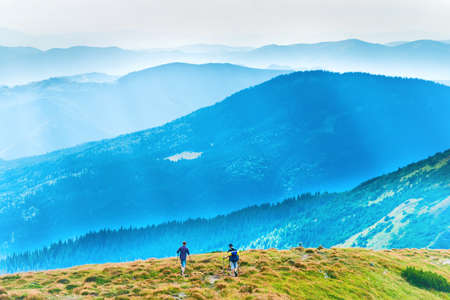 People travelling in mountains, mountain landscape with group of peopleの写真素材