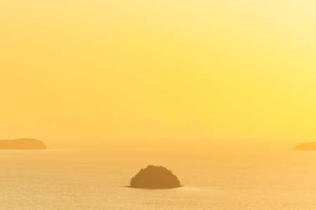 Many small islands landscape on sunset sea with colorful sunset skyの写真素材