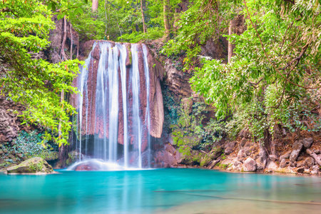 Beautiful waterfall and emerald lake in green tropical jungle forest. Nature landscape of Erawan National park, Kanchanaburi, Thailandの写真素材
