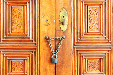 Old wooden door with doorknob and metal ring