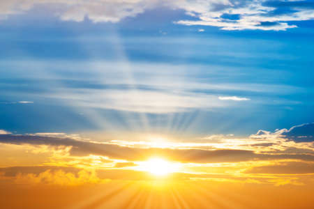 Sunset sky with sun rays and sunset cloudsの写真素材