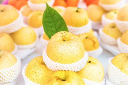 Stacks of fresh organic ripe yellow apples packed in baskets at healthy food marketの写真素材