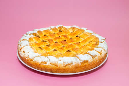 Tradition american apple pie with suger crust on pink backgroundの写真素材