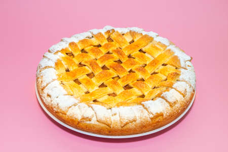Tradition american apple pie with suger crust on pink backgroundの写真素材