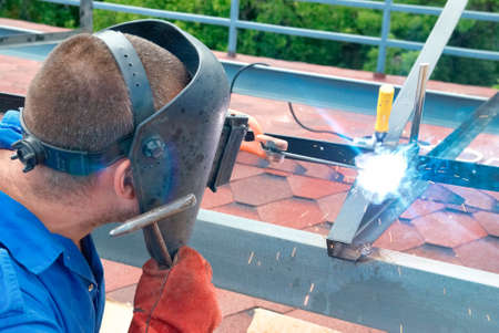 Welder man at factory working with metal constructionの写真素材