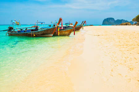 Sea beach landscape with boats and white sand beach with moored boats on tropical islandの写真素材