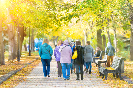 Crowd of people walking in autumn fall city parkの写真素材