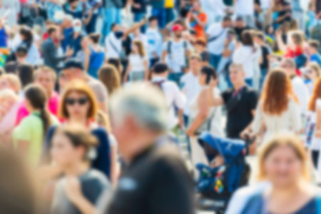 Crowd of people with blurred men and women on busy city streetの写真素材