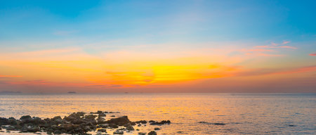 Sunset beach with sea, rocks and sunset panoramic skyの写真素材