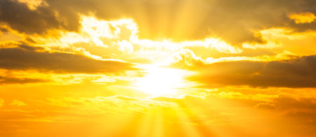 Sunset sky panorama with sunset clouds, sun rays and gramatic skyの写真素材