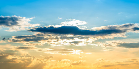 Sunset sky panorama background with sun and sunset cloudsの写真素材