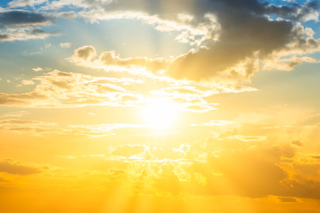 Sunset sky background with sun and sunset cloudsの写真素材