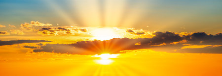 Sunset dramatic sky panorama background with sun and sunset cloudsの写真素材