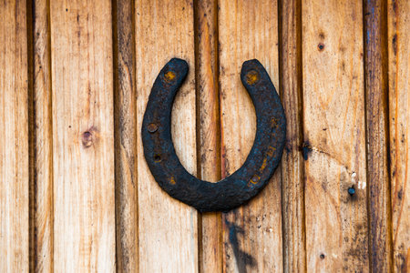 Old rustic horseshoe on wooden wall. Rust horse shoe for luckの写真素材