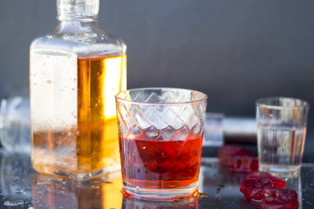 Vodka and whiskey in the bottle, vodka and whiskey in glass with ice, alcoholic drink