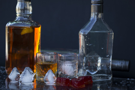 Vodka and whiskey in the bottle, vodka and whiskey in glass with ice, alcoholic drinkの写真素材