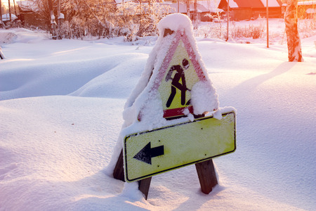Road warning sign for pedestrians covered with snow.の写真素材