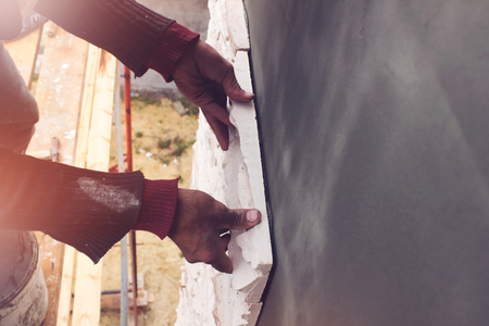 Bricklayer puts a wall house made of artificial stoneの写真素材
