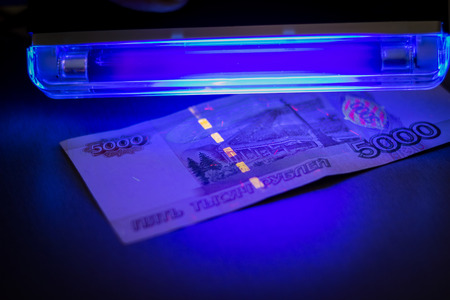 Checking the banknote UV lamp. Check money on falseの写真素材
