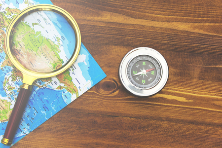 Map, magnifying glass and compass on the table. Concept on the theme of travelの写真素材