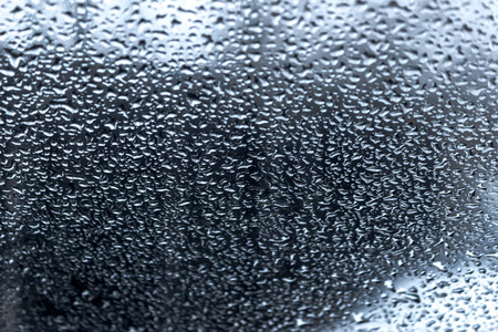 Water Drops on glass against a dark backgroundの写真素材