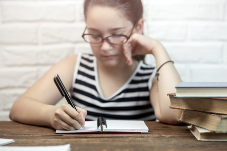 Schoolgirl doing homework at the tableの写真素材