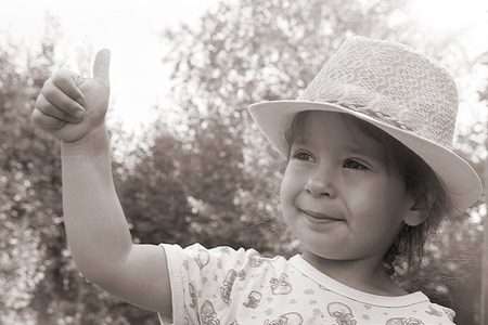 Vintage, little girl in a hat on the nature close upの写真素材