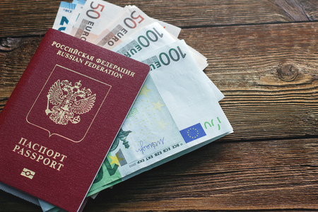 Passport and banknote euro on a wooden tableの写真素材