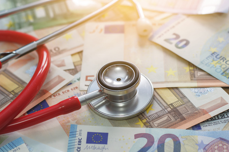 Money and stethoscope on a beige backgroundの写真素材