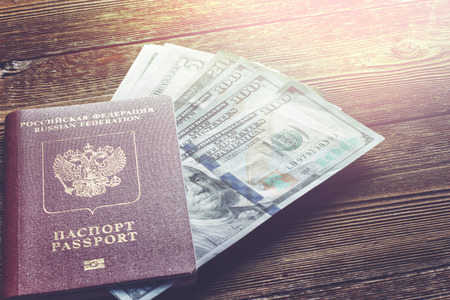 Passport and dollars on a wooden tableの写真素材