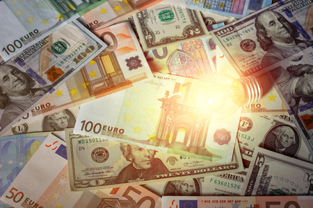 Glowing light bulb on a background of moneyの写真素材