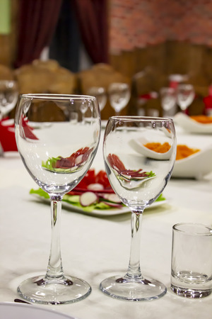 Transparent glasses stand on the background of a covered tableの写真素材