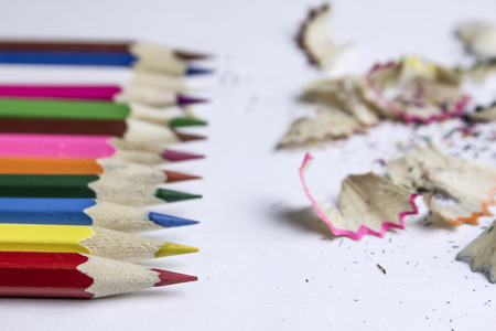 On the white table are colored pencils and sawdustの写真素材