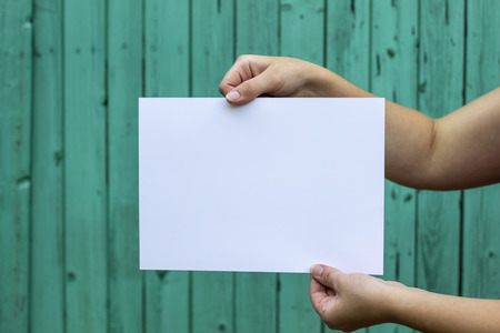 Woman holding a white sheet in a horizontal positionの写真素材
