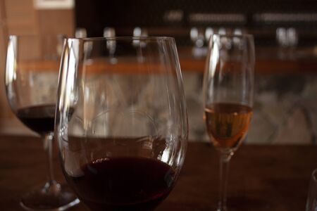 Trio of glasses to taste wine front glass with red wine to test density with legs or tears that form...